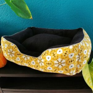 Panier pour chats avec tissu intérieur doux de couleur noire et tissu extérieur en coton de couleur jaune à motifs vintages de fleurs et formes géométriques blanches, grises et noires